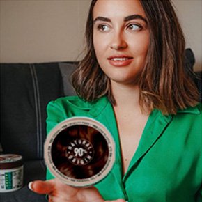Woman holding tub of Garnier GOOD hair dye