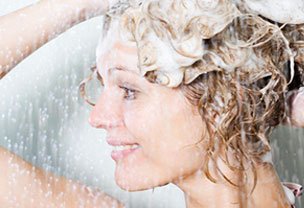 Woman lathering shampoo on head